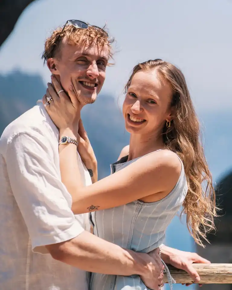 Boyfriend and girlfriend looking extremely happy after he proposed with sea in the background
