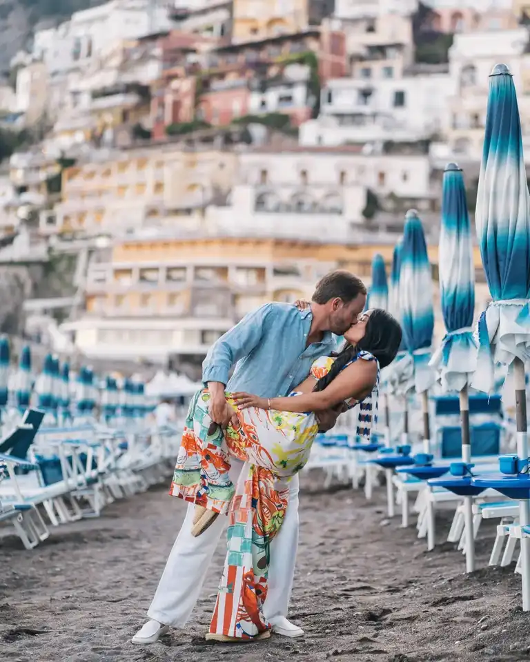 Couple having an intimate moment as they both go for a dip on the sand of Positano beach