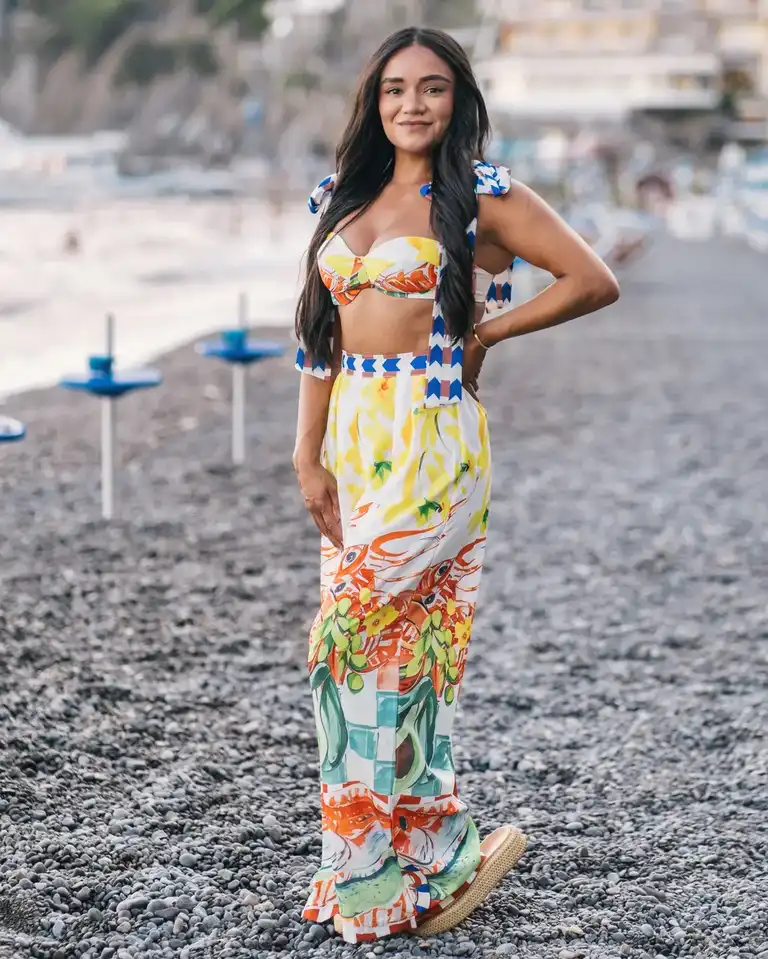 Woman wearing a colorful two pieces in Positano, with bright illustrations on pants and contrast colors