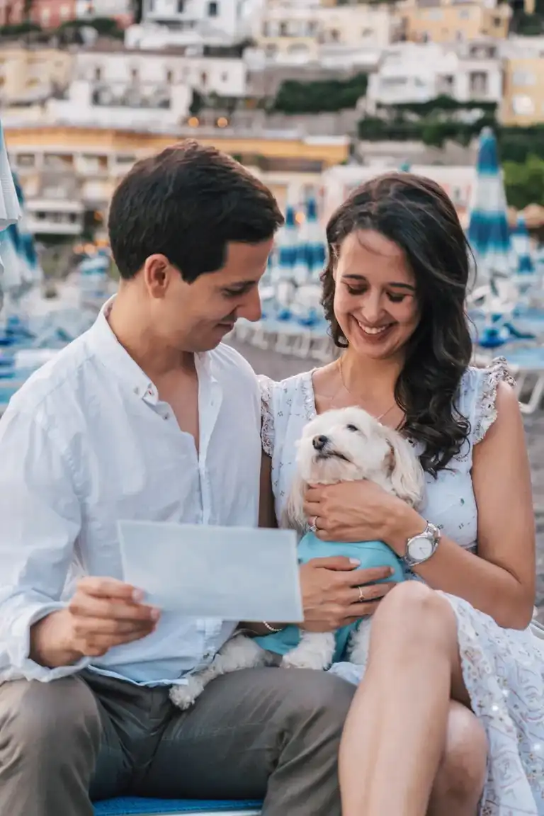 Couple playing with their dog by Spiaggia Grande in Positano
