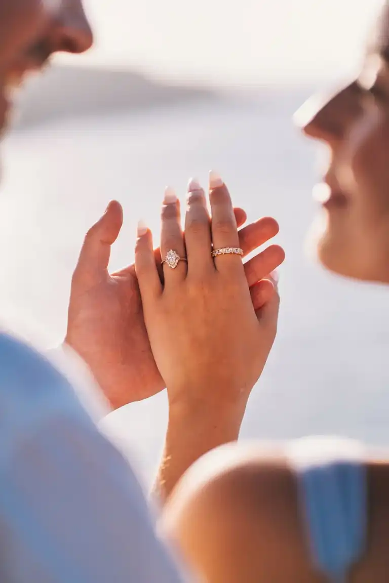 Couple holding hands together showcasing engagement ring as they look at each other after the proposal in Sorrento