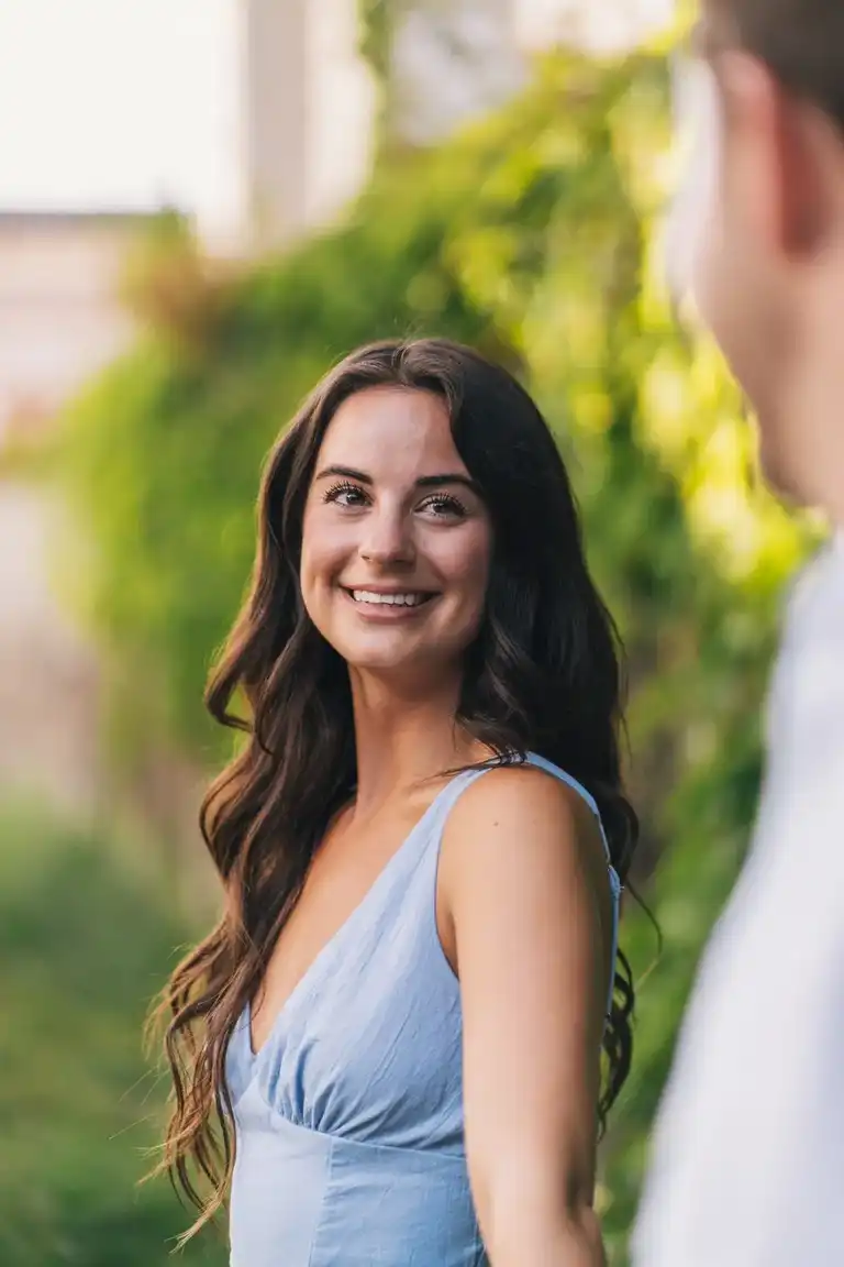 Smiling girl in focus looking at her boyfriend out of focus after he proposed in Sorrento
