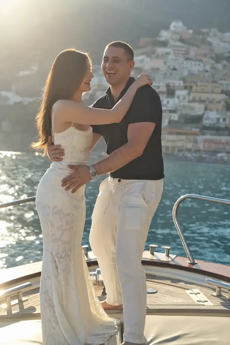 Couple laughing as they hug each other for a photoshoot on a boat in Positano