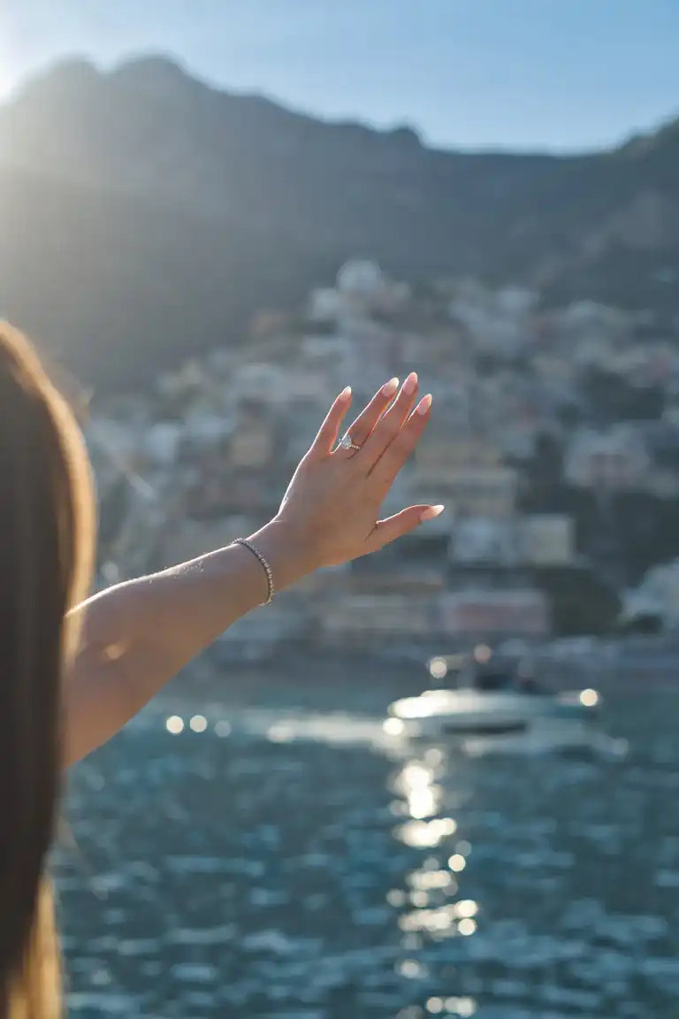 Just proposed girlfriend look at the ring on her hand pointed towards Positano during a photoshoot