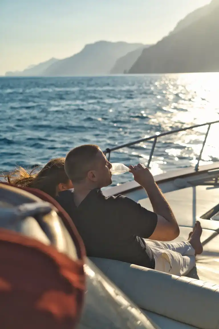 Couple sitting on a boat sipping champagne after proposal in Positano