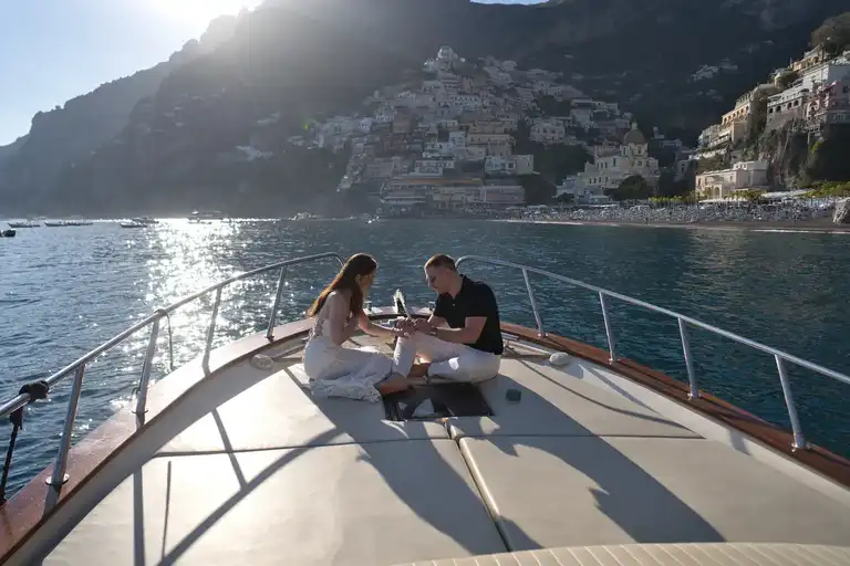 Couple on boat in Positano sitting on the front side with Positano in the background
