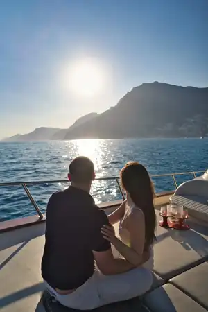 Couple on a boat in Positano looking at the sunset, taken from behind