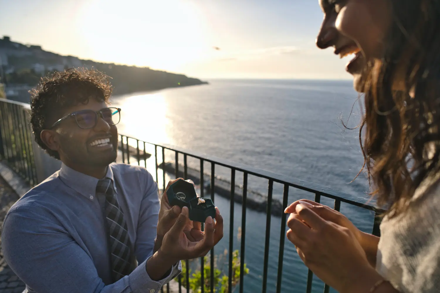 Man proposing to his girlfriend in Villa Comunale in Sorrento. The man is on his knees with a box and a ring being hold in his hands