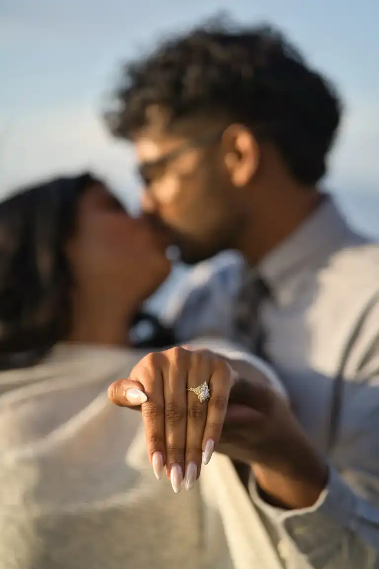 Couple kissing as they show the proposal ring to the camera 