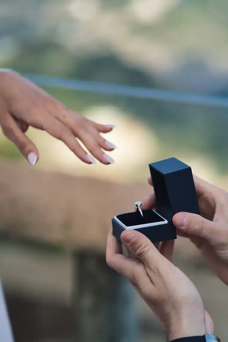 detail picture of man proposing to his girlfriend, box with the ring at the center of the image