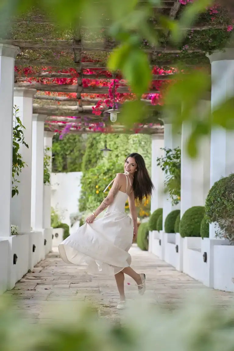 A portrait of the bride standing on a white, arches-and-geometric patio with a traditional tiled floor, providing a unique architectural viewpoint within Borgo Sant'Andrea.