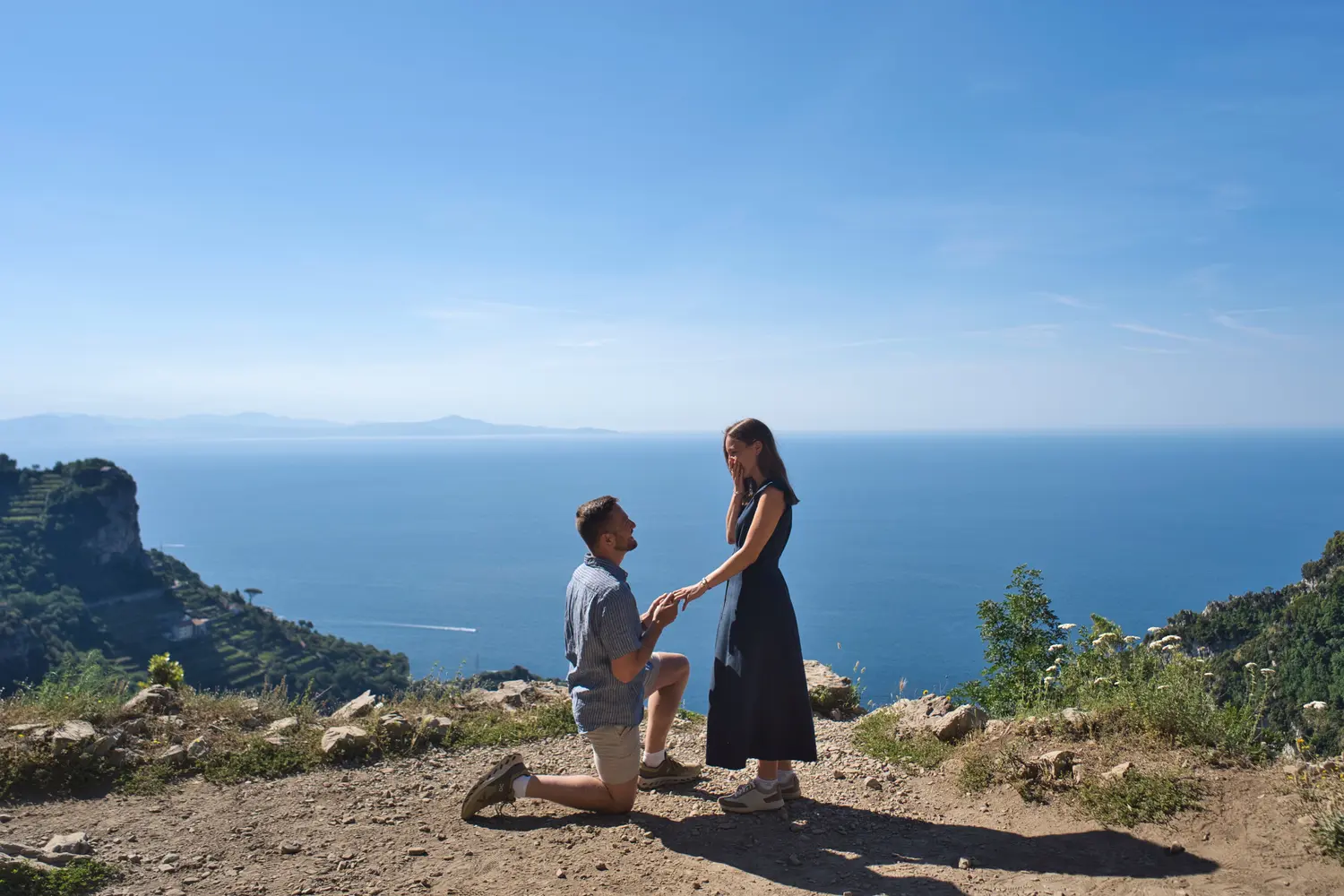Couple embracing on a scenic viewpoint overlooking the sea and mountains during a hike on the Path of the Gods near Bomerano Amalfi Coast.
