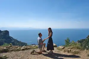 Couple embracing on a scenic viewpoint overlooking the sea and mountains during a hike on the Path of the Gods near Bomerano Amalfi Coast.