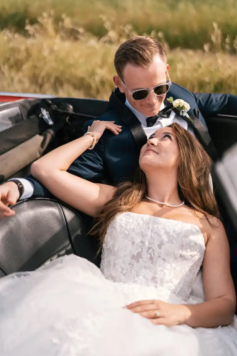 Bride and Broom share a romantic moment in the backseat of a vintage italian car