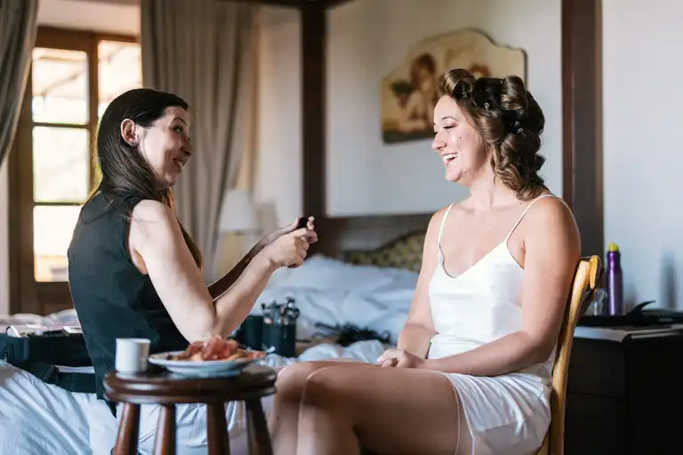 Bride getting ready with her makeup stylist in the comfort of her room