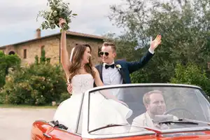 A couple just got married in Tuscany Villa celebrating on a vintage Alfa Spider car with a driver